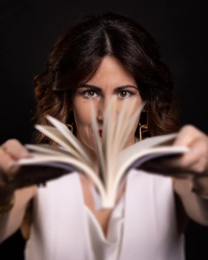 Marianna Natale che sfoglia le pagine del suo romanzo "un sogno nel cassetto"